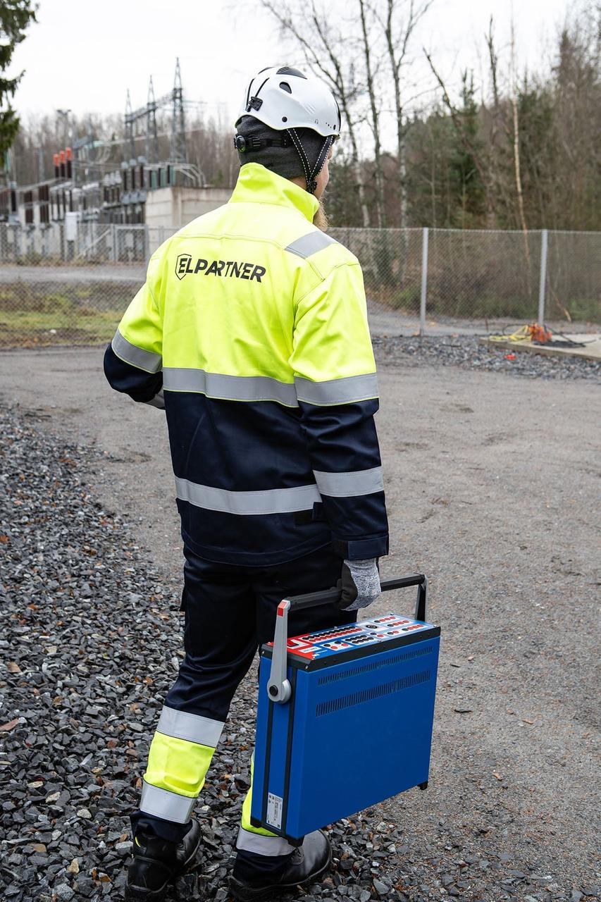 Elpartner engineer carrying test equipment at a substation